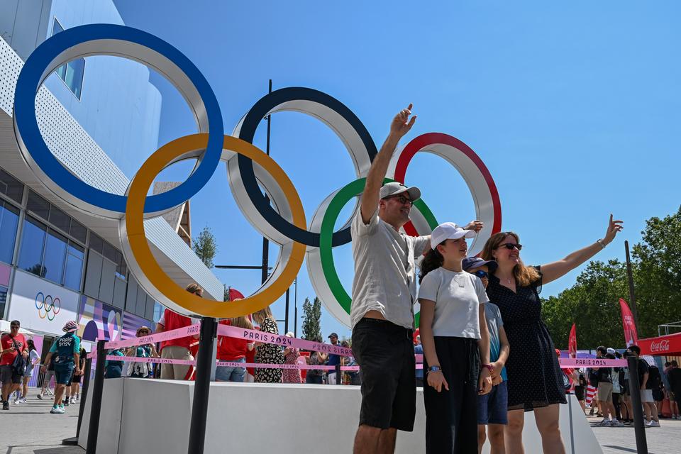 Suporter berfoto dengan latar belakang lambang olimpiade saat menyaksikan pertandingan bulu tangkis Olimpiade Paris 2024 di Porte De La Chapella Arena, Paris, Prancis, Senin (29/7/2024).