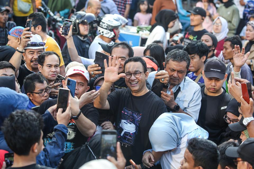 Mantan Gubernur DKI Jakarta Anies Baswedan (tengah) menyapa warga saat Hari Bebas Kendaraan Bermotor di Jl. Jend. Sudirman, Jakarta, Minggu (4/8/2024). Anies yang diusung oleh Partai NasDem sebagai bakal calon gubernur DKI Jakarta pada Pilkada 2024 itu me