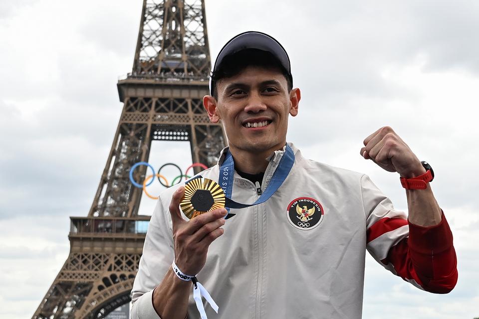 Atlet panjat tebing Indonesia Veddriq Leonardo berfoto dengan latar belakang Menara Eiffel di Champions Park, Trocadero, Paris, Prancis, Jumat (9/8/2024). 