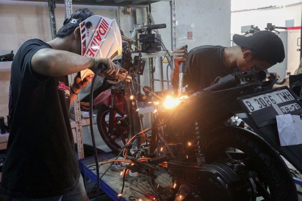 Teknisi menyelesaikan proses konversi motor berbahan bakar minyak menjadi motor listrik di bengkel PT. Tomara Jaya Perkasa, Jakarta Timur, Selasa (13/8/2024). Kementerian Energi dan Sumber Daya Mineral (ESDM) mengadakan program konversi motor listrik grat