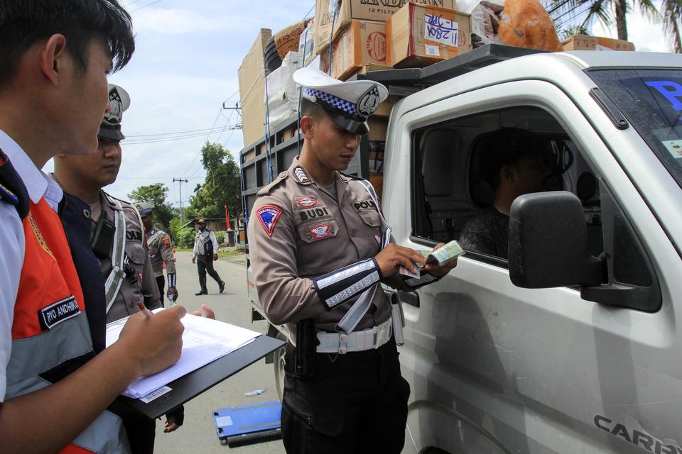 Polisi dan petugas Dinas Perhubungan Kota Jayapura memeriksa surat kendaran angkutan barang saat operasi pengawasan dan penindakan kendaraan over load over dimension(ODOL) di Jalam Raya Waena Sentani, Kota Jayapura, Papua, Kamis (22/08/2024). 