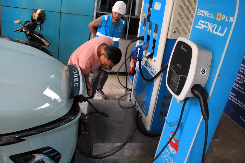 Pelanggan mengisi daya mobil listrik di Stasiun Pengisian Kendaraan Listrik Umum (SPKLU) di Medan, Sumatera Utara, Sabtu (24/8/2024). PT PLN Unit Induk Distribusi (UID) Sumatera Utara menambah 15 unit SPKLU yang tersebar di wilayahnya untuk mendukung pela