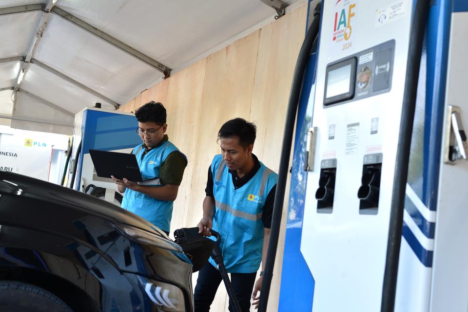 Petugas menyiapkan Stasiun Pengisian Kendaraan Listrik Umum (SPKLU) untuk pengisian daya baterai kendaraan listrik di Nusa Dua, Badung, Bali, Selasa (27/8/2024). 