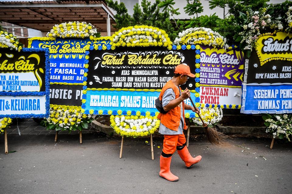 Petugas kebersihan menyapu di dekat karangan bunga tanda duka cita ekonom Faisal Basri di Jakarta, Kamis (5/9/2024). Faisal Basri meninggal dunia di RS Mayapada pada hari Kamis (5/9/2024) pukul 03.30 WIB pada usia 65 tahun dan akan dimakamkan di TPU Mente