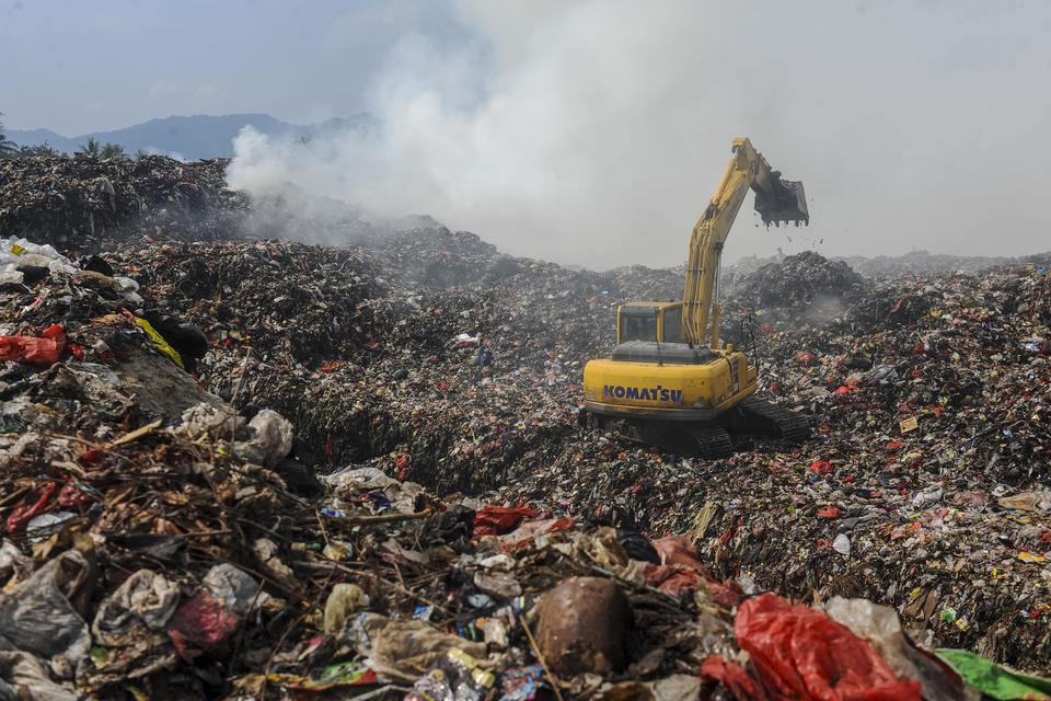 Petugas menggunakan alat berat melakukan pemadaman dengan mengubur sampah di TPSA Bagendung, Kota Cilegon, Banten, Selasa (17/9/2024).