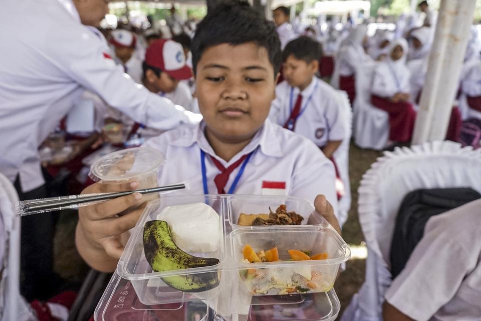 Pelajar menunjukan makanan bergizi gratis saat uji coba pemberian makanan bergizi gratis di Lapangan Dracik, Kabupaten Batang, Jawa Tengah, Rabu (18/9/2024). Program makan bergizi gratis yang merupakan program unggulan Prabowo-Gibran itu diikuti 3.000 pel