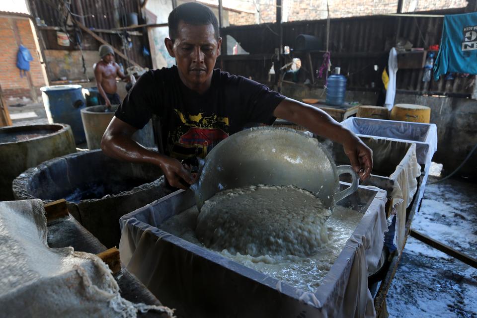 Perajin menuangkan cairan kacang kedelai ke dalam kotak cetakan saat proses produksi tahu di salah satu usaha industri tahu tradisional di Banda Aceh, Aceh, Sabtu (21/9/2024). 