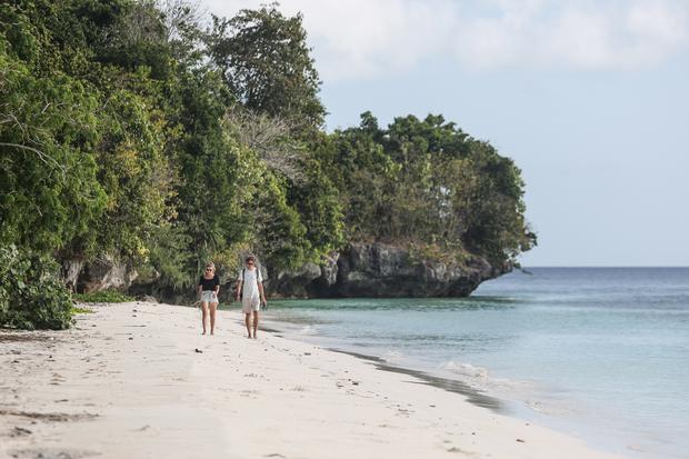 Wisatawan berjalan di Pantai Hondue di Desa Kollo Soha, Kecamatan Tomia, Kabupaten Wakatobi, Sulawesi Tenggara, Sabtu (21/9/2024). 