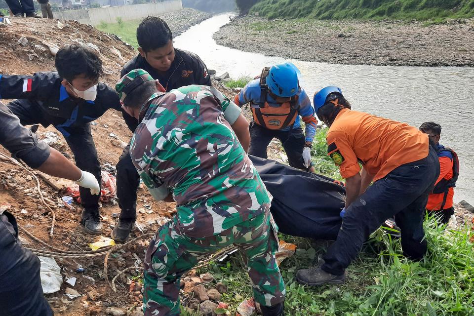 Petugas BPBD Kota Bekasi bersama anggota TNI mengevakuasi satu dari tujuh jenazah laki laki yang ditemukan mengambang di Kali Bekasi, Pondok Gede Permai, Jatiasih, Kota Bekasi, Minggu (22/9/2024). Kepolisian masih menyelidiki penyebab kematian tujuh orang