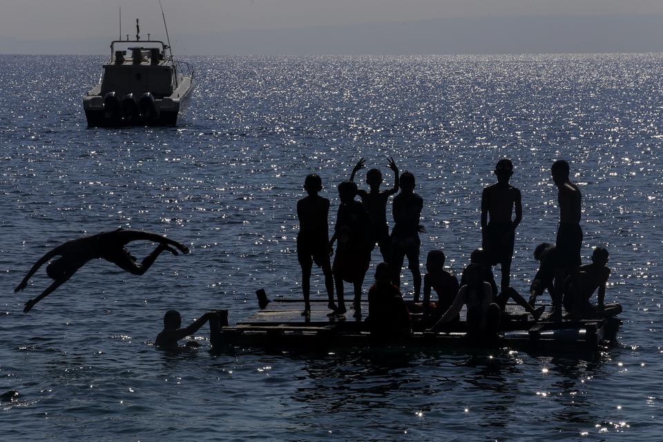Sejumlah warga berada di atas karamba saat berenang di Pantai Falajawa, Ternate, Maluku Utara, Minggu (22/9/2024). Pantai Falajawa tersebut merupakan daerah reklamasi yang dikembangkan oleh pemerintah daerah sebagai zona ekonomi dan destinasi wisata yang