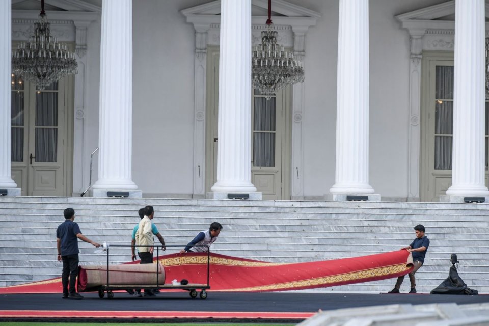 Pekerja menyiapkan karpet merah untuk acara pisah sambut presiden di halaman Istana Merdeka, Jakarta, Sabtu (19/10/2024).