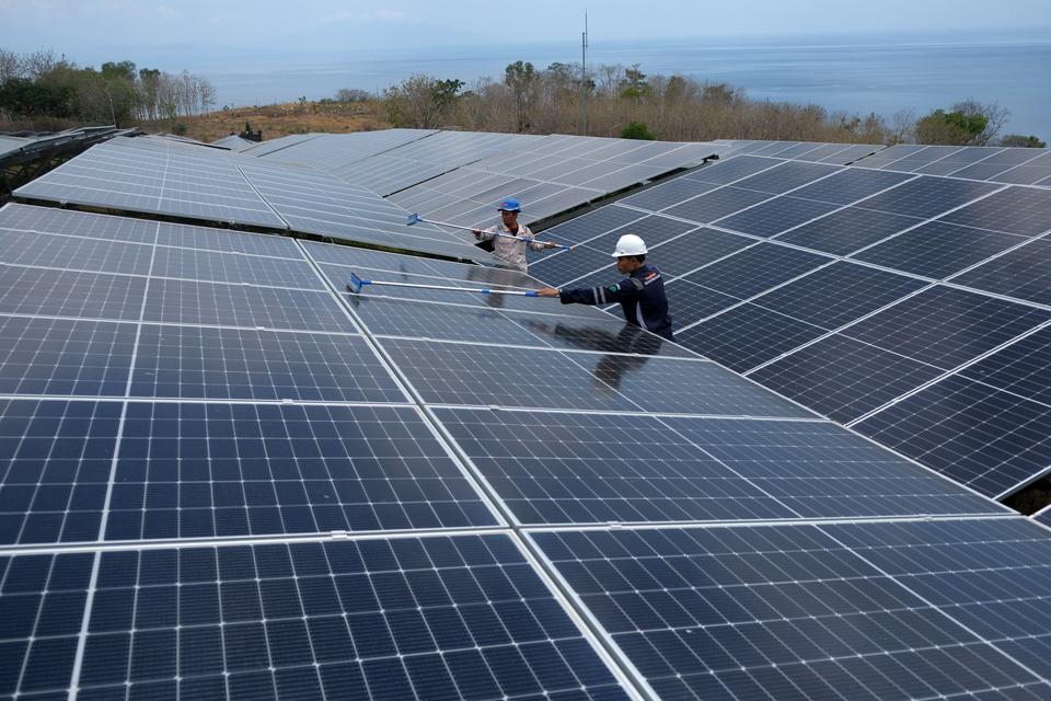 Dua petugas PLN Indonesia Power UBP Bali membersihkan panel surya pada Pembangkit Listrik Tenaga Surya (PLTS) di Pulau Nusa Penida, Klungkung, Bali, Selasa (22/10/2024). 