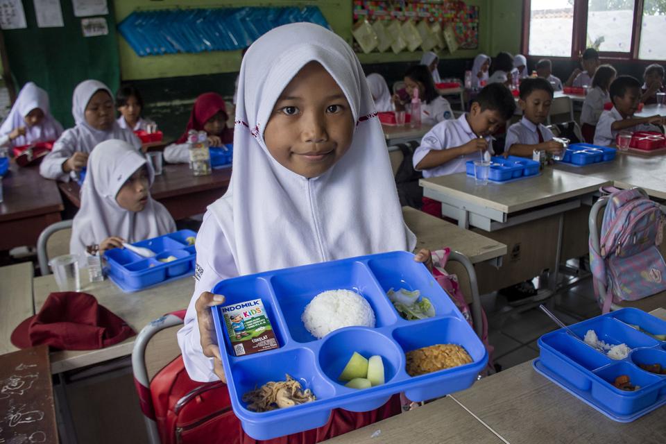 Pelajar menunjukkan menu makanan saat program makan bergizi gratis di SDN 3 Cipatat, Kabupaten Bandung Barat, Jawa Barat, Kamis (24/10/2024).