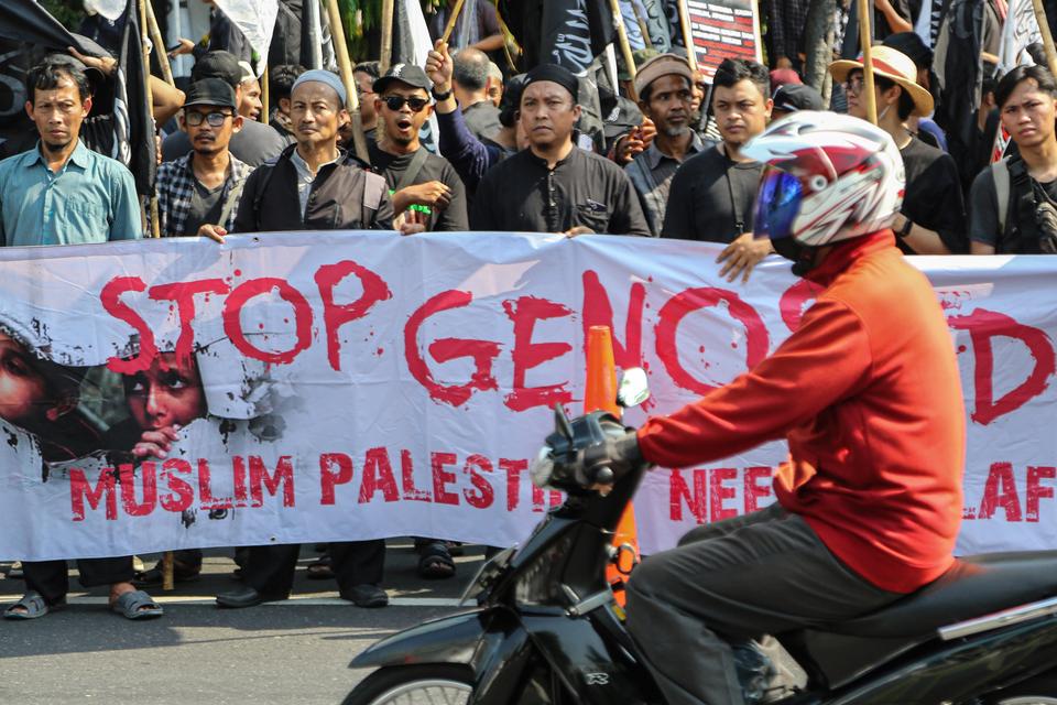 Sejumlah warga membentangkan spanduk saat mengikuti aksi solidaritas bela Palestina di kawasan Jalan Pahlawan Simpang Lima, Semarang, Jawa Tengah, Sabtu (26/10/2024).