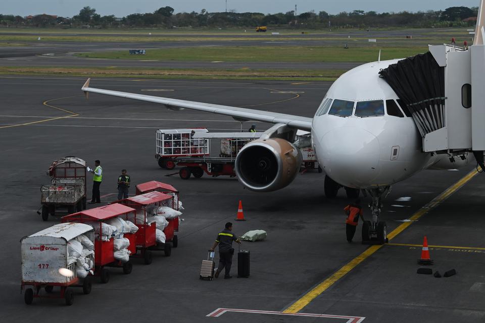 Petugas membawa bagasi penumpang ke pesawat di Bandara Internasional Juanda Surabaya, Jawa Timur, Minggu (3/11/2024). Menko Bidang Perekonomian Airlangga Hartarto mengungkapkan perkembangan terkait penurunan harga tiket pesawat, saat ini Satgas Penurunan 