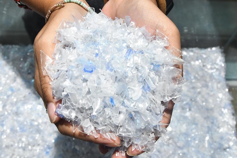 Pekerja menunjukkan botol plastik yang telah dicacah di Amandina Bumi Nusantara, Cikarang Pusat, Kabupaten Bekasi, Jawa Barat, Senin (4/11/2024). Pabrik daur ulang botol plastik tersebut mengolah 40.000 ton Recycle Polyethylene Terephthalate (RPET) guna 