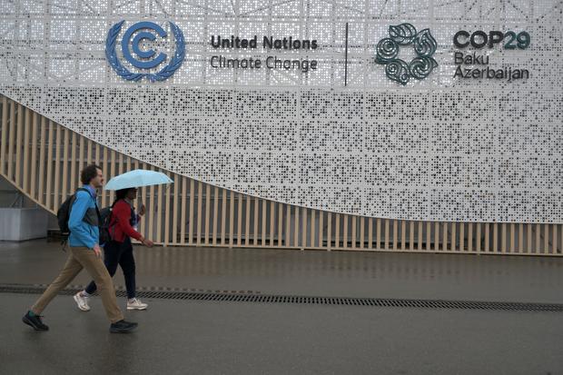 Anggota delegasi berjalan di area pelaksanaan Konferensi Perubahan Iklim (COP29) di Baku, Azerbaijan, Sabtu (9/11/2024). 