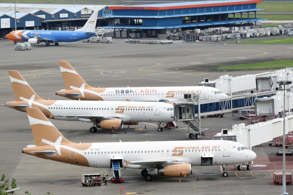 Petugas darat melakukan bongkar muat sebuah pesawat komersil di Bandara Soekarno Hatta, Tangerang, Banten, Kamis (28/11/2024). Pemerintah sepakat menurunkan harga tiket pesawat untuk penerbangan domestik sebesar 10 persen selama periode Natal 2024 dan Tah