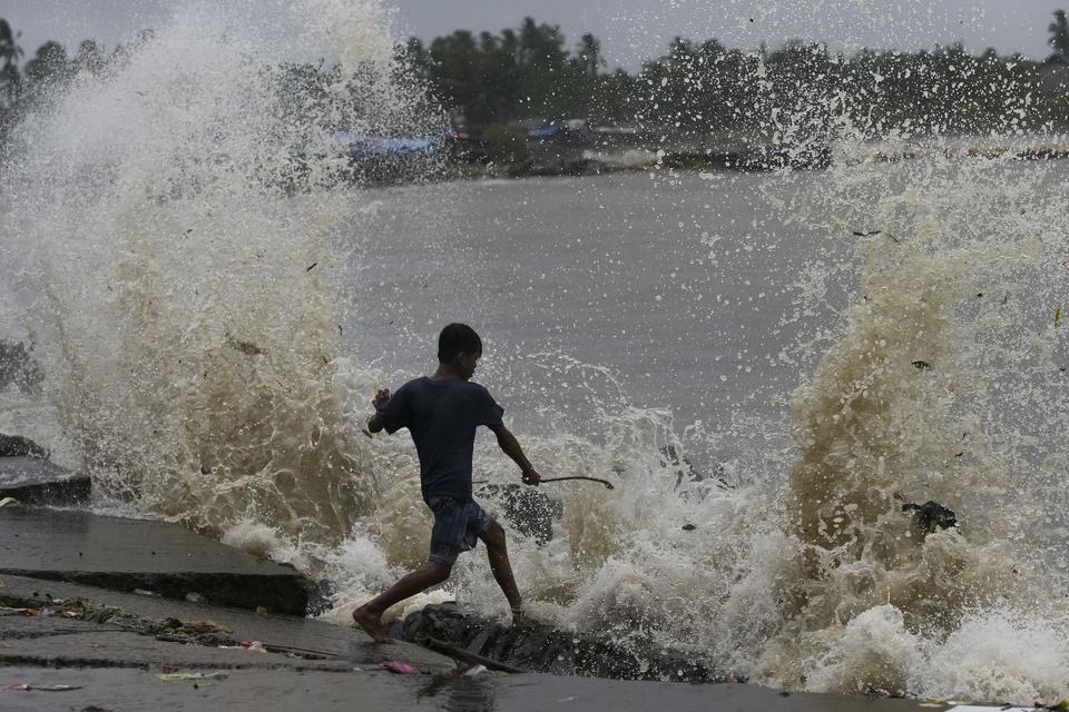 Seorang anak bermain di bibir pantai saat ombak dan angin kencang menerjang di Desa Teluk, Labuan, Kabupaten Pandeglang, Banten, Senin (2/12/2024).