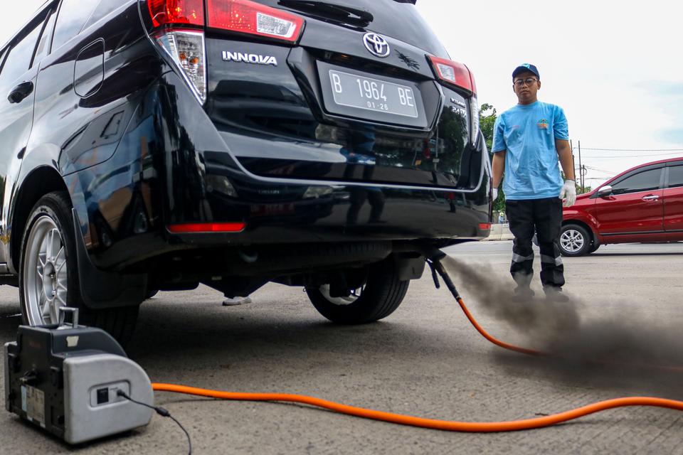 Petugas mengukur kualitas emisi gas buang kendaraan roda empat saat uji emisi gratis di Jalan Perintis Kemerdekaan, Jakarta, Selasa (3/12/2024). 