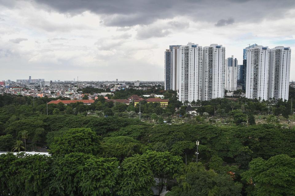 Lanskap pepohonan dengan latar belakang gedung bertingkat di Karet Kuningan, Jakarta Selatan, Jumat (13/12/2024). Pemerintah Provinsi DKI Jakarta berkomitmen menambah RTH yang saat ini baru mencapai 5,3 persen atau seluas 34,46 juta meter persegi dari lu