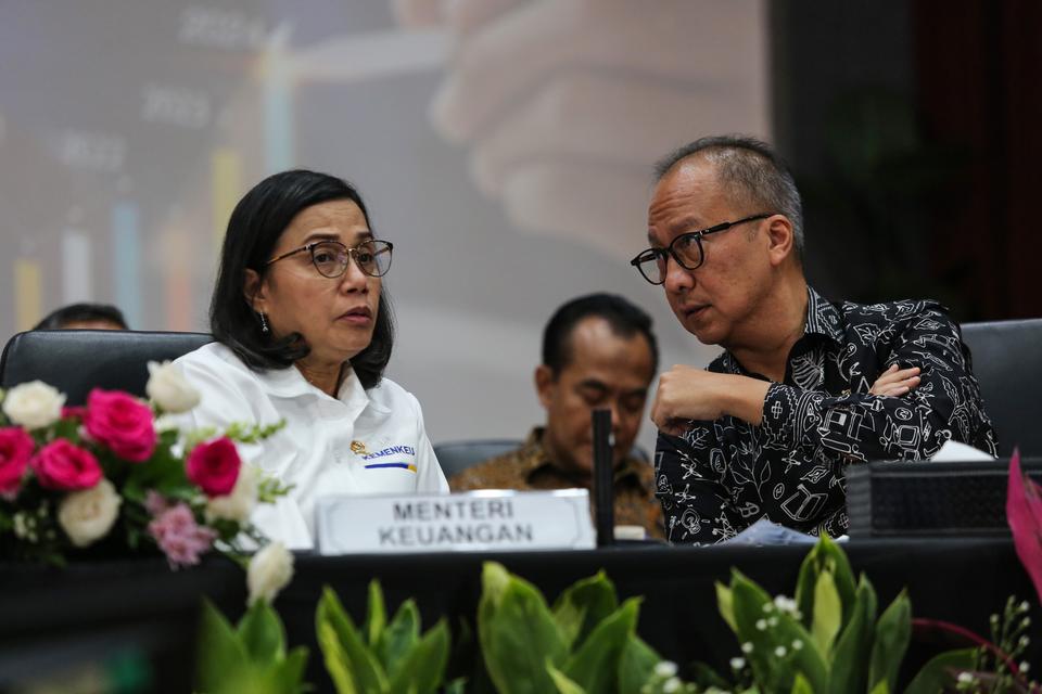 Menteri Keuangan Sri Mulyani (kiri) berbincang dengan Menteri Perindustrian Agus Gumiwang (kanan) saat konferensi pers di kantor Kemenko Perekonomian, Jakarta, Senin (16/12/2024). Konferensi pers tersebut membahas Paket Kebijakan Ekonomi akselerasi pertum