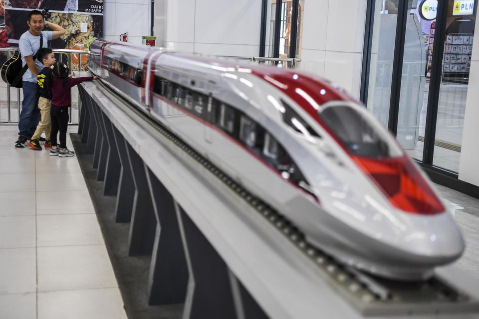 Calon penumpang kereta cepat Whoosh berfoto di samping miniatur Whoosh di Stasiun Halim, Jakarta, Senin (16/12/2024). 