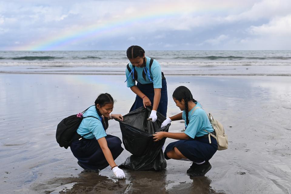 Tiga pelajar memungut sampah saat kegiatan aksi bersih sampah laut di Pantai Kuta, Badung, Bali, Sabtu (4/1/2025). 