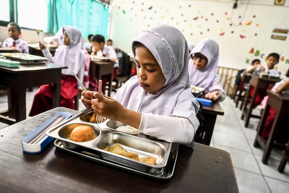 Seorang murid menyantap makanan bergizi gratis di SDN 15 Slipi, Jakarta, Senin (6/1/2025). 