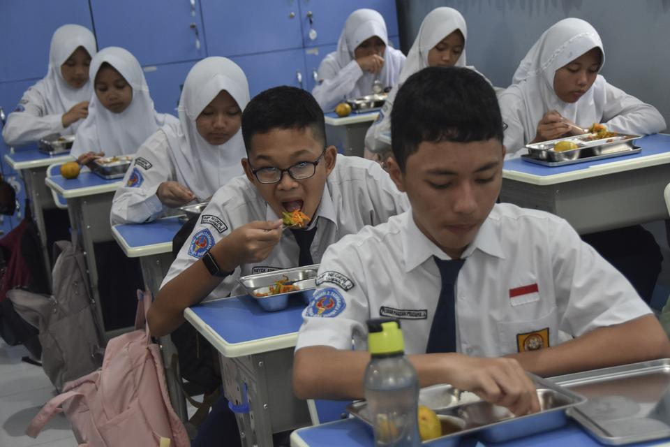 Siswa menyantap makanan bergizi gratis di SMP Negeri 2 Tasikmalaya, Kota Tasikmalaya, Jawa Barat, Senin (6/1/2025). 