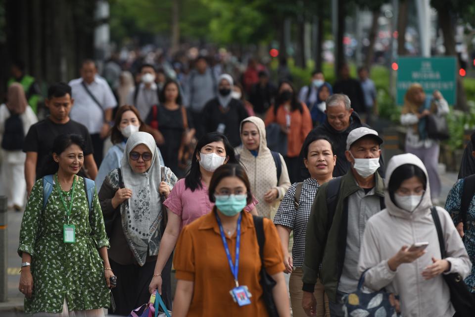 Pekerja melintasi pedestrian saat jam pulang kerja di kawasan Jalan Jenderal Sudirman, Jakarta, Selasa (7/1/2025). 