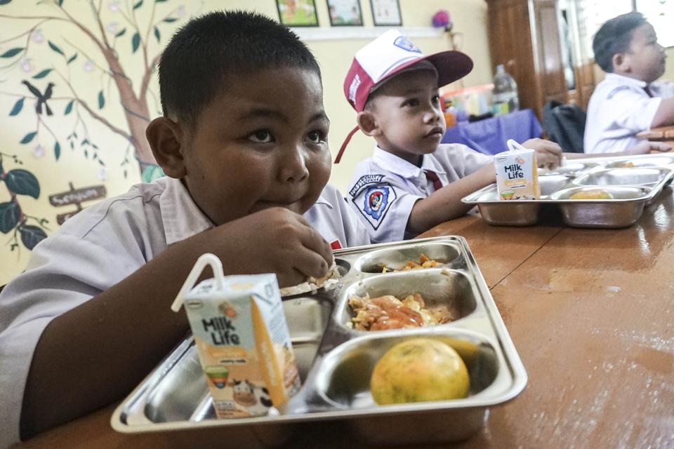 Pelajar menyantap makanan bergizi saat pelaksaaan perdana program Makan Bergizi Gratis (MBG) di SD Negeri Kandeman 01, Kabupaten Batang, Jawa Tengah, Senin (13/1/2025).