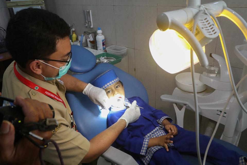 Dokter memeriksa kondisi kesehatan gigi seorang anak saat program cek kesehatan gratis perdana di Puskesmas Ngadiluwih, Kabupaten Kediri, Jawa Timur, Selasa (11/2/2025). Program tersebut mulai diberlakukan di 19 puskesmas se-Kabupaten Kediri sebagai upaya