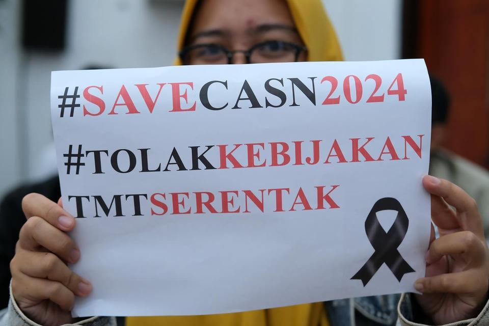 Seorang Calon Aparatur Sipil Negara (CASN) membawa poster saat mengikuti aksi penolakan penundaan pengangkatan CASN di Kantor Gubernur Kalimantan Barat, Senin (10/3/2025). 