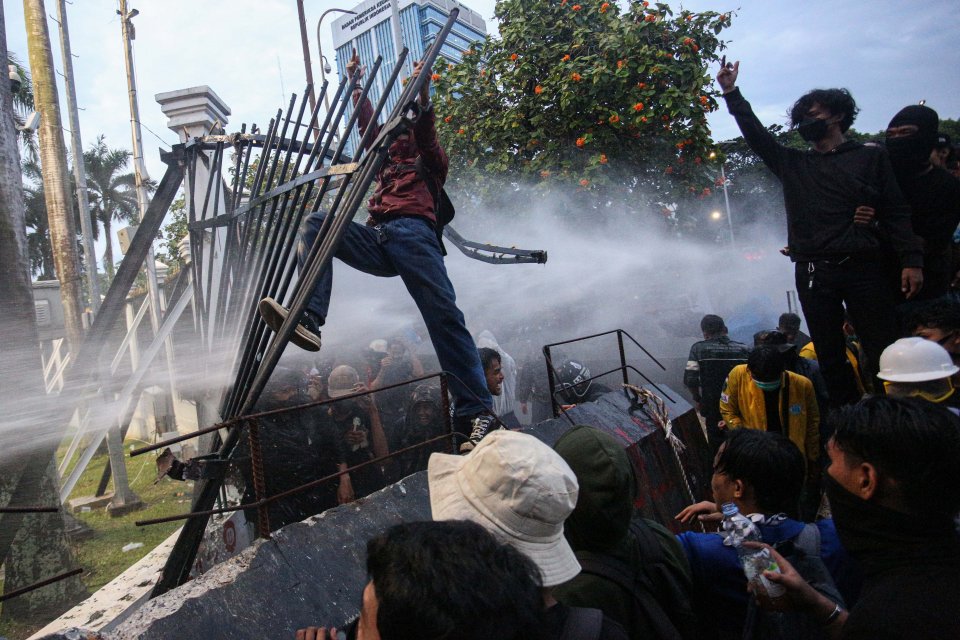 Pengunjuk rasa berusaha merobohkan pagar pembatas saat menggelar aksi demonstrasi terkait Revisi Undang-Undang TNI di depan gedung DPR, Senayan, Jakarta, Kamis (20/3/2025). 