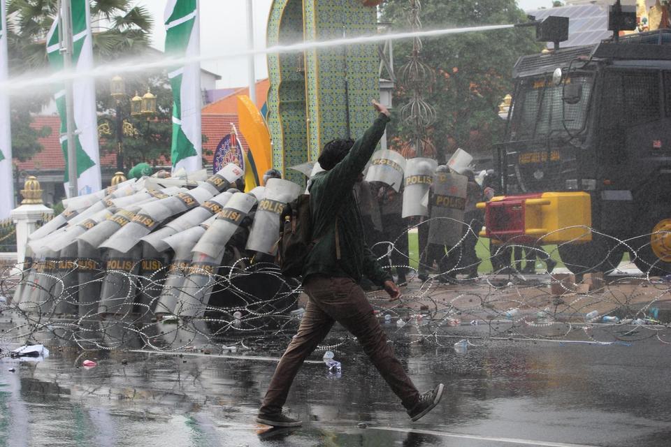 Polisi menyemprotkan air dari water canon untuk menghalau sejumlah pengunjuk rasa yang beraksi untuk menyikapi UU TNI di Surabaya, Jawa Timur, Senin (24/3/2025). Polrestabes Surabaya mengerahkan 1.128 personel Polri untuk mengamankan unjuk rasa yang berla