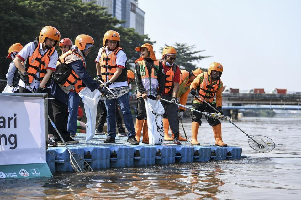 Petugas Dinas Lingkungan Hidup (DLH) DKI Jakarta bersama karyawan Wings Group, warga dan relawan membersihkan sampah di Sungai CIliwung di kawasan Tambora, Jakarta, Minggu (27/4/2025). DLH DKI Jakarta bersama Yayasan Wings Peduli dan Waste 4 Change mengge