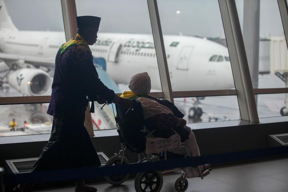 Jamaah calon haji berjalan menuju pesawat saat pemberangkatan di Terminal 1 Bandara Internasional Juanda Surabaya di Sidoarjo, Jawa Timur, Jumat (2/5/2025). Sebanyak 376 jamaah calon haji kloter pertama Embarkasi Surabaya dari Kabupaten Tulungagung dibera