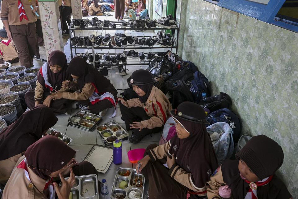 Siswa menyantap hidangan saat program makan bergizi gratis (MBG) di SD Negeri Banjarsari 5, Kota Serang, Banten, Jumat (2/5/2025).