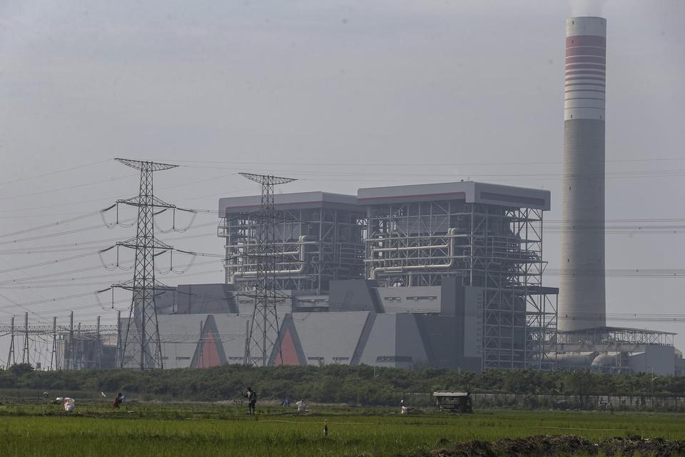 Petani menebar pupuk di area persawahan sekitar lokasi Pembangkit Listrik Tenaga Uap (PLTU) Jawa 7, Kabupaten Serang, Banten, Jumat (30/5/2025). Menteri Energi dan Sumber Daya Mineral Bahlil Lahadalia mengatakan pemerintah berencana membangun PLTU sebesar