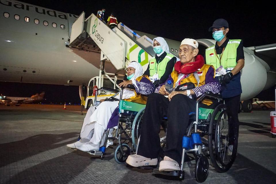 Petugas mendorong kursi roda dua orang haji dari kelompok terbang (kloter) pertama debarkasi Balikpapan setibanya di Bandara Internasional Sultan Aji Muhammad Sulaiman (SAMS) Sepinggan, Balikpapan, Kalimantan Timur, Selasa (17/6/2025) dini hari. Sebanyak 