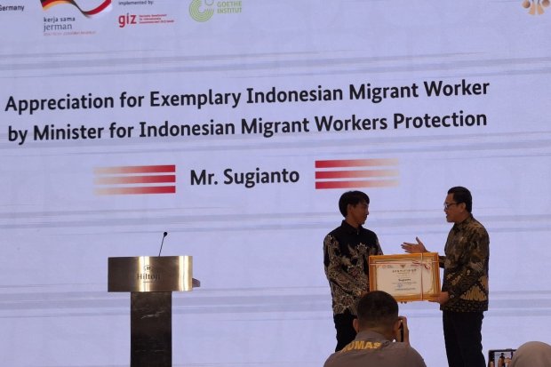 Menteri P2MI Abdul Kadir Karding memberikan penghargaan kepada pekerja migran Indonesia, Sugianto, yang menyelamatkan lansia dari kebakaran hutan di K