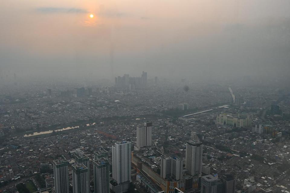 Suasana lanskap kota yang diselimuti polusi udara di Jakarta, Rabu (25/6/2025). Kementerian Lingkungan Hidup mencatat sejumlah penyebab pencemaran udara di Jabodetabek yaitu sebesar 42-57 persen dari emisi kendaraan bermotor, 14 persen dari emisi industri
