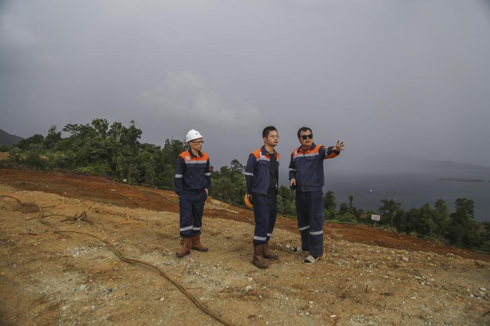 Tiga karyawan FT Feni Haltim melihat lokasi proyek usai peresmian peletakan batu pertama pembangunan proyek Ekosistem Industri Baterai Kendaraan Listrik Terintegrasi Konsorsium ANTAM-IBC-CBL di Tanjung Buli, Kabupaten Halmahera Timur, Maluku Utara, (Mingg