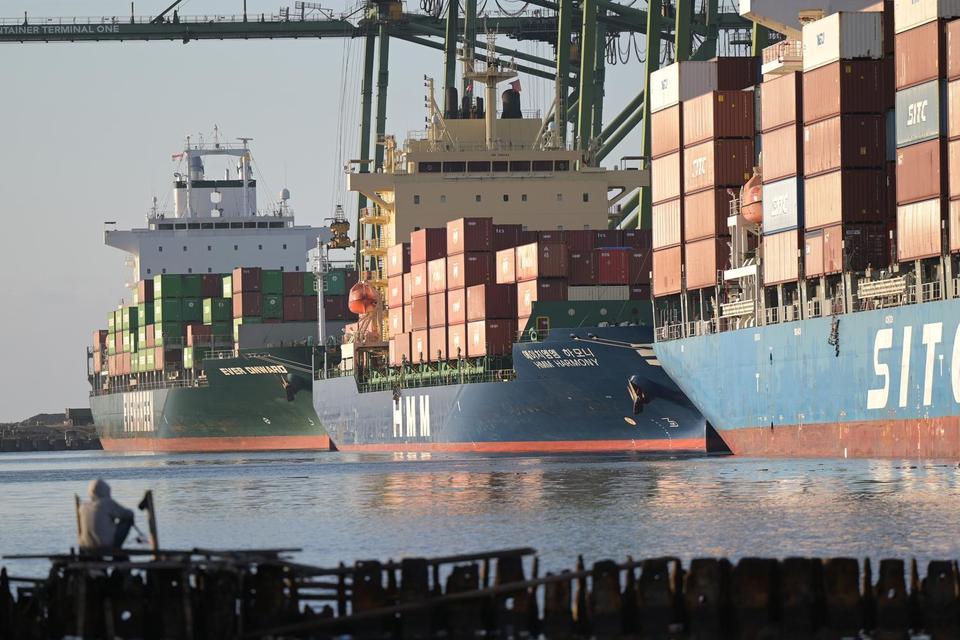 Seorang warga memancing saat adanya aktivitas bongkar muat peti kemas di New Priok Container Terminal One, Jakarta, Selasa (1/7/2025). Badan Pusat Statistik menyatakan Indonesia memperoleh surplus neraca perdagangan sebesar 4,30 miliar dolar AS pada Mei 2
