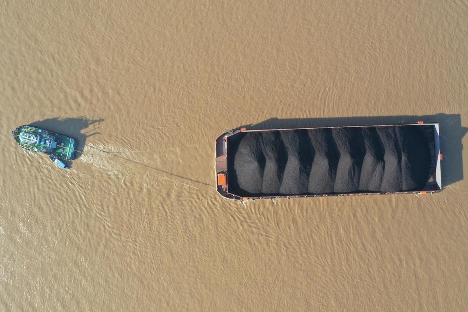 Foto udara kapal tongkang pengangkut batu bara melintas di Sungai Mahakam, Samarinda, Kalimantan Timur, Minggu (13/7/2025). Menurut data dari Kementerian Energi dan Sumber Daya Mineral (ESDM) pada 2025, produksi batu bara Indonesia ditargetkan menjadi 739