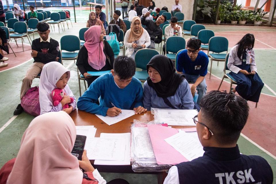 Siswa didampingi orang tua mengisi data untuk Sekolah Rakyat Bandung di Polteksos Bandung, Jawa Barat, Senin (14/7/2025).Sebanyak 52 siswa dan 48 siswi tingkat sekolah menengah atas mulai mengikuti masa pengenalan lingkungan sekolah dan asrama Sekolah Rak