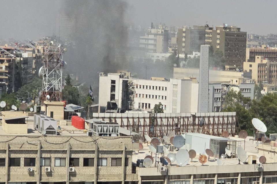 Asap mengepul dari Kompleks Staf Umum tentara Suriah setelah pesawat tempur Israel melancarkan beberapa serangan udara di Damaskus, Suriah, pada 16 Juli 2025. Gedung tersebut menjadi sasaran tiga kali sepanjang hari, dengan api yang terlihat jelas dan asa