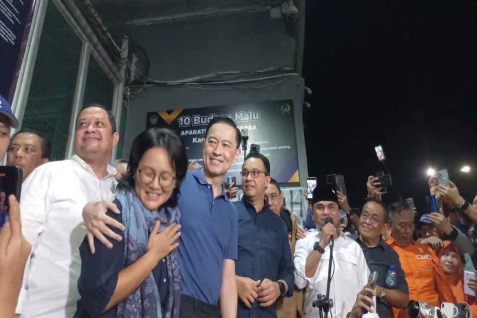 Tom Lembong merangkul istrinya saat keluar dari rumah tahanan Cipinang Jumat malam (1/8).