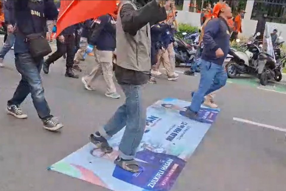 Massa aksi buruh di DPR menginjak spanduk bergambar politikus, Kamis (28/7)